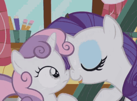 a couple of ponies standing next to each other and kissing