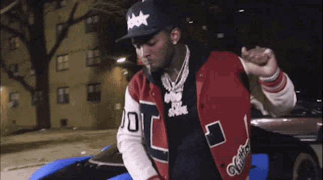a man wearing a baseball cap and a varsity jacket has the number 10 on his shirt