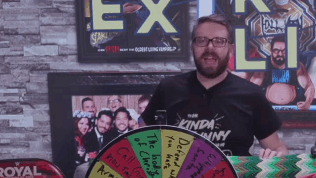 a man in a kinda funny shirt stands in front of a wheel