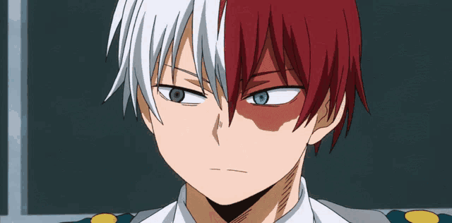 a close up of a boy with red and white hair and blue eyes