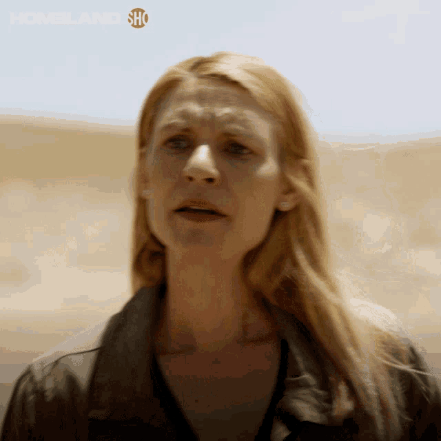 a close up of a woman 's face with a homeland show logo in the corner