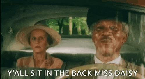 a man and a woman are sitting in the back of a car . the man is wearing a hat and bow tie .