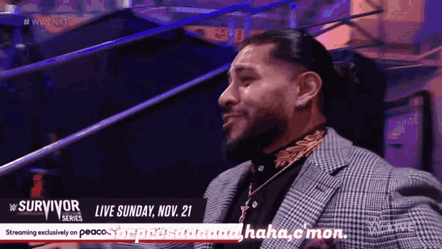a man in a suit is talking on a wrestling show