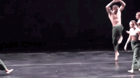 a group of people are dancing on a stage and one of them is jumping in the air