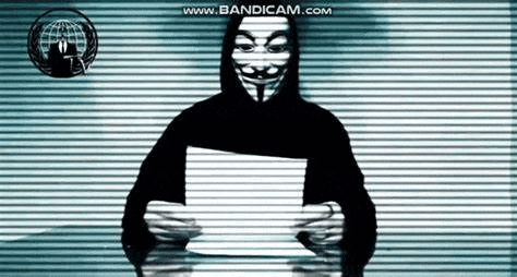 a man in a mask is holding a piece of paper in front of a wall .