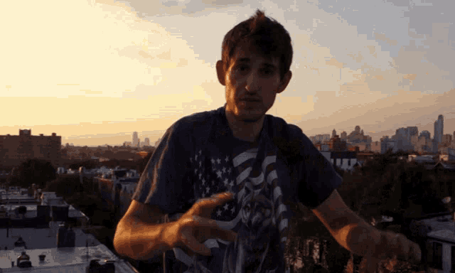 a man in an american flag shirt is standing on a rooftop