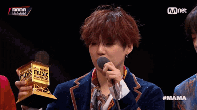 a man is holding a trophy that says music on it