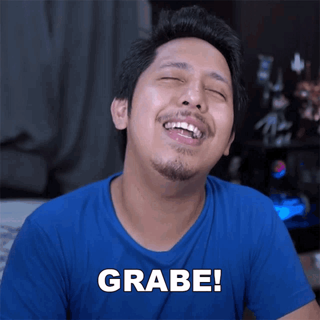 a man in a blue shirt is laughing with the word grabe written on the bottom