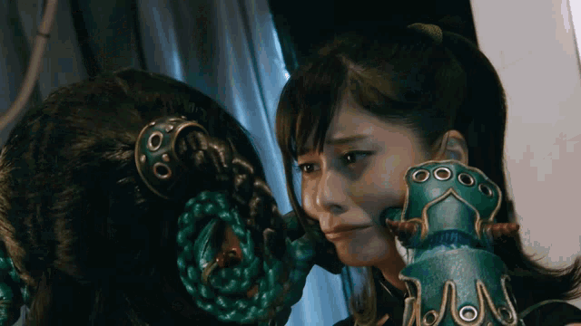 a woman with a green glove with holes in it looks at another woman