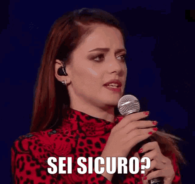 a woman is singing into a microphone with the words sei sicuro written below her