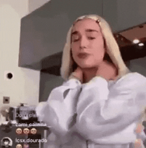 a woman with blonde hair is wearing a white shirt and a white jacket .