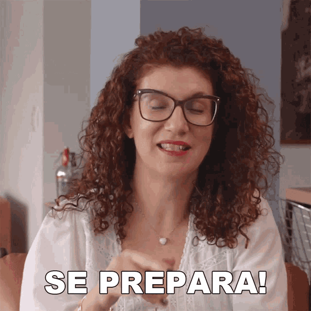 a woman with curly hair and glasses says " se prepara "