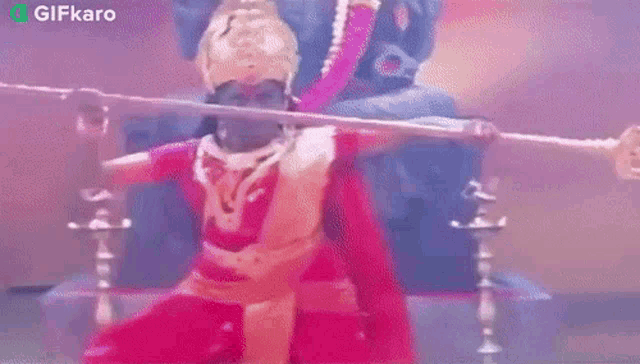 a woman in a red dress is holding a sword in her hand .