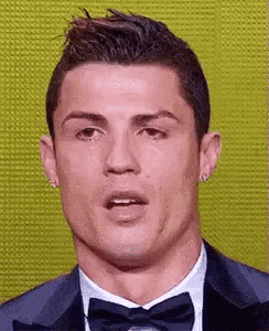 a close up of a man wearing a suit and bow tie .