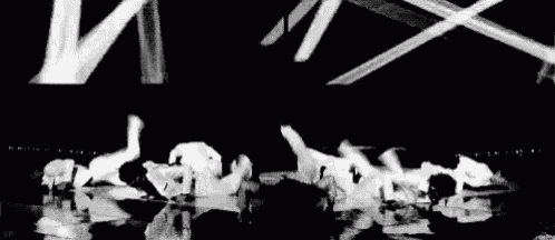 a black and white photo of a group of dancers on a stage .
