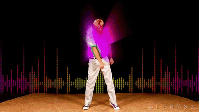 a man in a green shirt is dancing in front of a black background