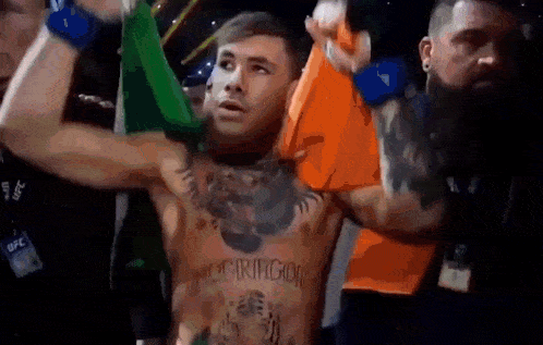 a man with a tattoo on his chest that says mcgregor is holding a flag .
