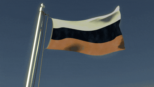 a russian flag is flying in the wind against a blue sky