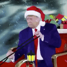 donald trump is wearing a santa hat and riding in a sleigh with presents .
