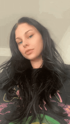 a woman with long black hair is wearing a t-shirt that says ' a ' on it
