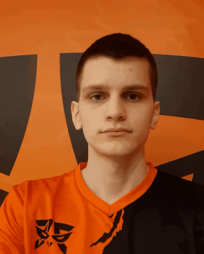 a young man wearing a black and orange shirt with an x on the front