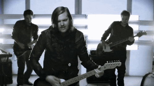 a man is playing a guitar with a fender logo on the neck