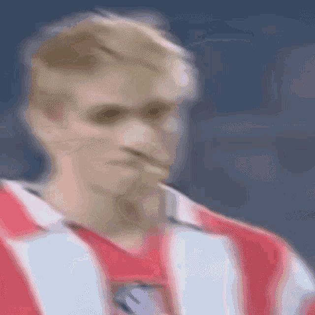 a blurry picture of a man in a red and white striped shirt .