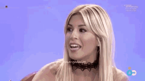 a woman wearing a choker and earrings is smiling on a tv show