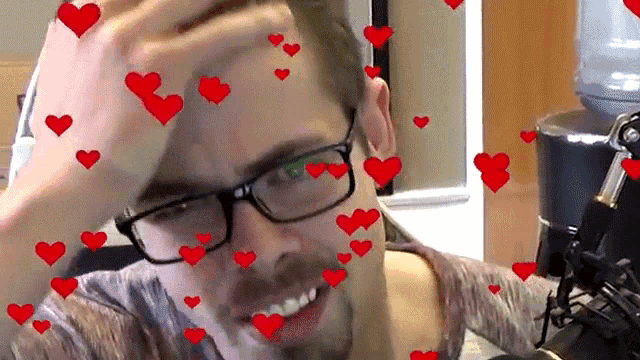 a man with glasses is surrounded by hearts on his face