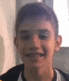 a young boy is smiling in a blurry photo .