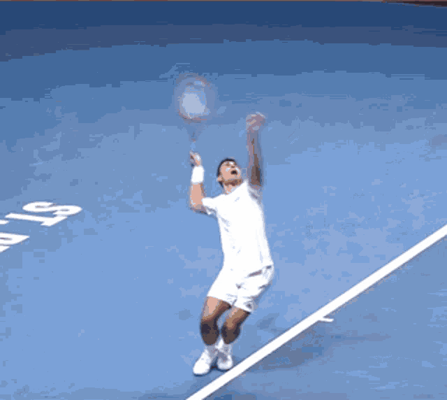 a man in white shorts is playing tennis on a blue court with the number 59 on it