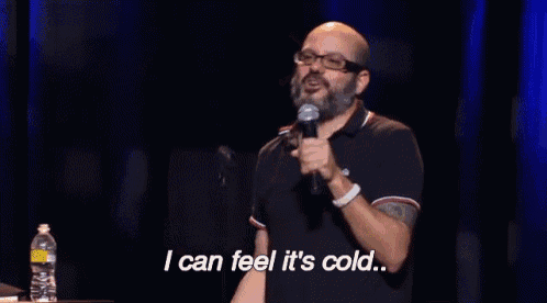a bald man speaking into a microphone with the words i can feel it 's cold