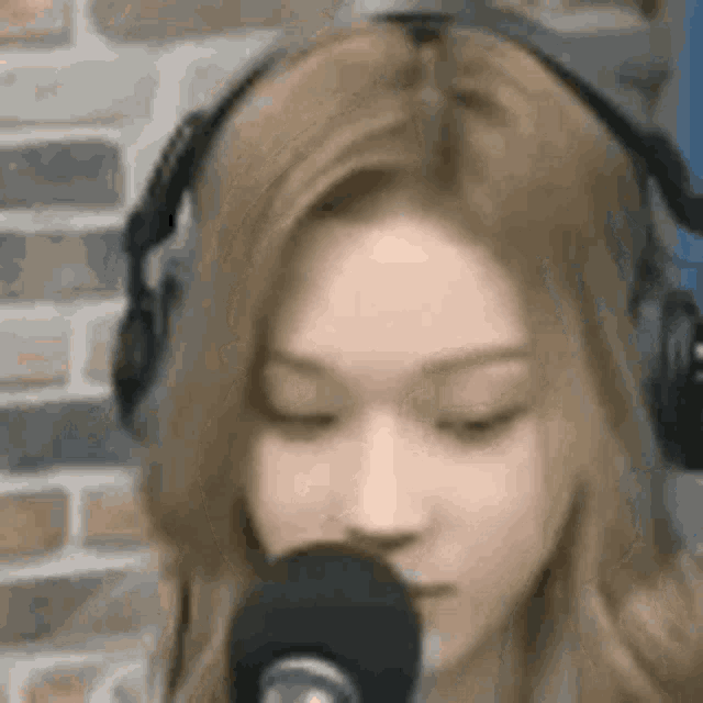 a close up of a woman wearing headphones and a microphone .