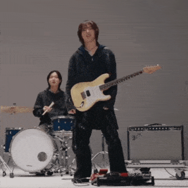 a man is playing a guitar in front of a fender amp