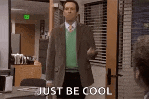 a man in a suit and tie is standing in front of a door and saying `` just be cool '' .