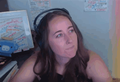 a woman wearing headphones looks at the camera in front of a white board with the word ' spongebob ' on it