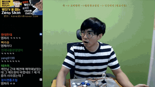 a man in a striped shirt sits in front of a screen that says zero skin on it