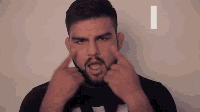 a man with a beard is making a face with his fingers