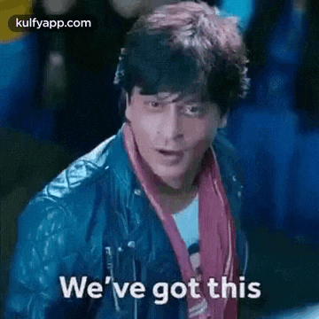 a man in a leather jacket and scarf is standing in front of a crowd and says `` we 've got this '' .