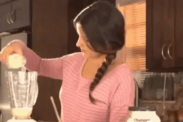 a woman is pouring something into a blender that says champier