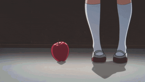 a girl is standing next to an apple on the floor