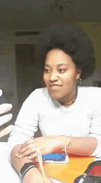 a woman is sitting at a desk with a pen in her hand