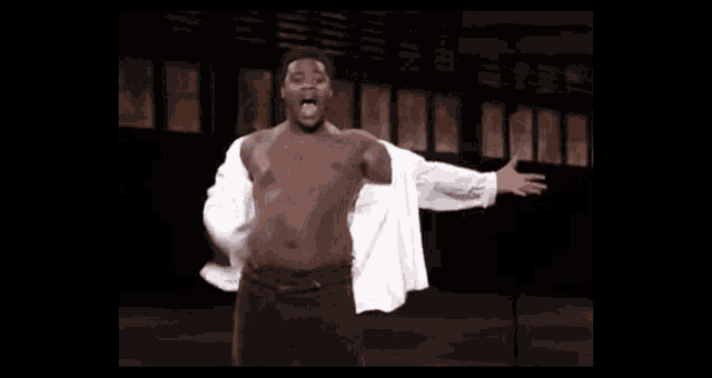 a shirtless man in a white shirt is dancing on a stage