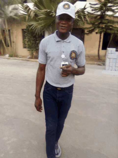 a man wearing a white hat and a grey shirt has a badge on his shirt that says ' nigeria ' on it