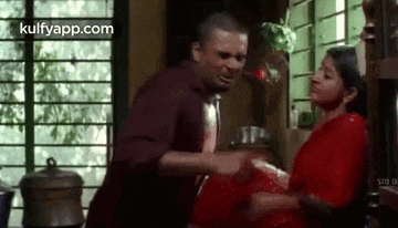 a man and a woman are standing next to each other in a kitchen .