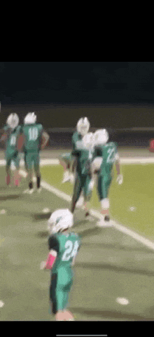 a group of football players are playing on a field .