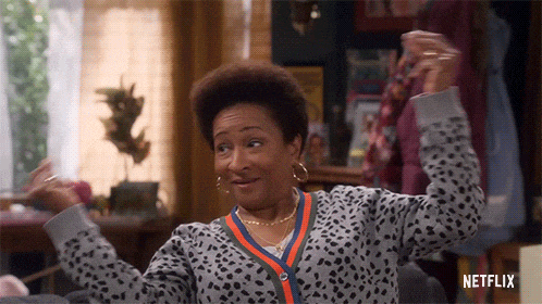 a woman is sitting on a couch with her arms in the air and a netflix logo on the bottom