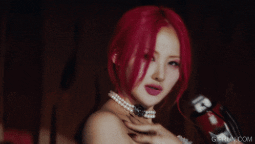 a woman with red hair is wearing a pearl necklace and a white dress
