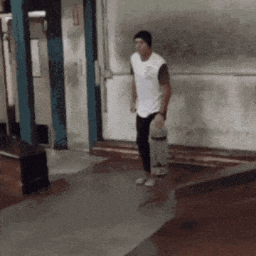 a man is holding a skateboard in front of a door