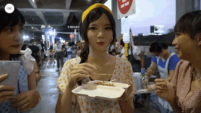 a girl holding a tray of food in front of a sign that says " dont enter "